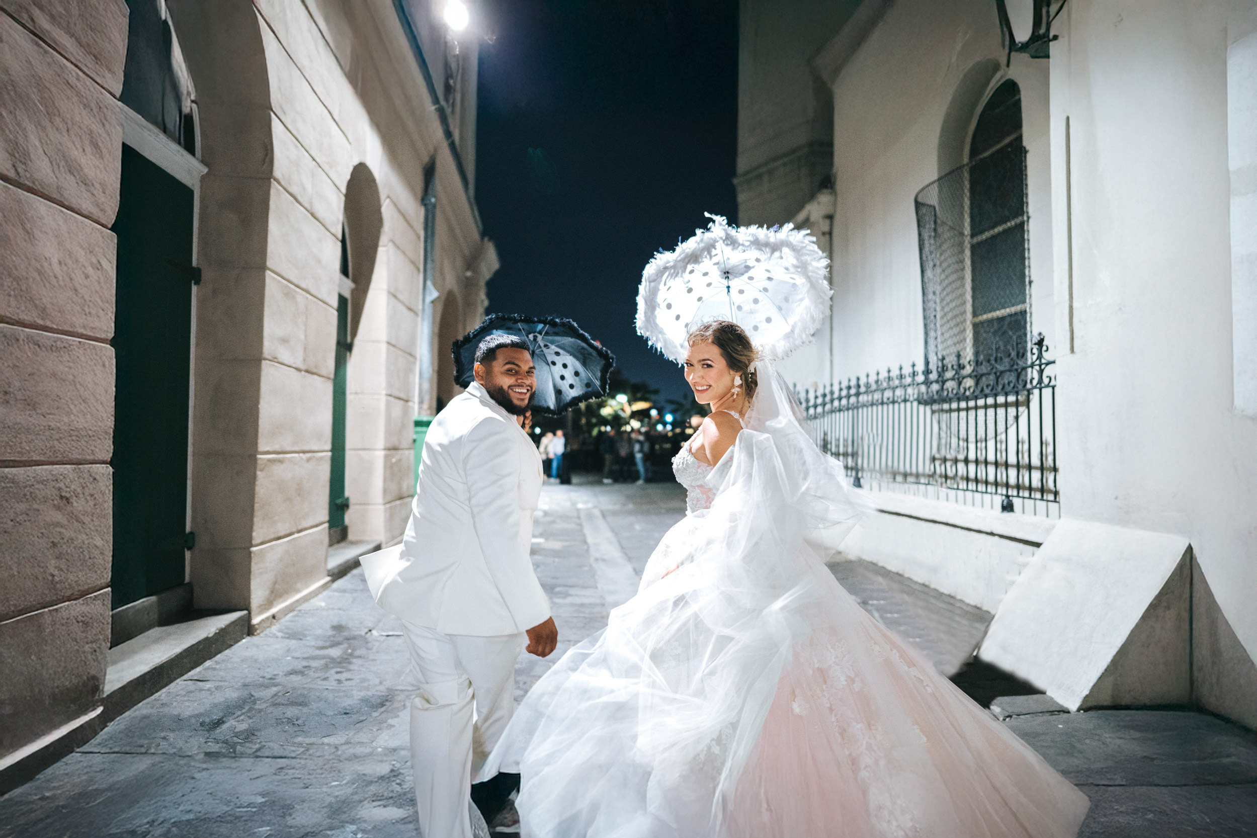 Bride and groom celebrating with their umbrellas in French Quarter