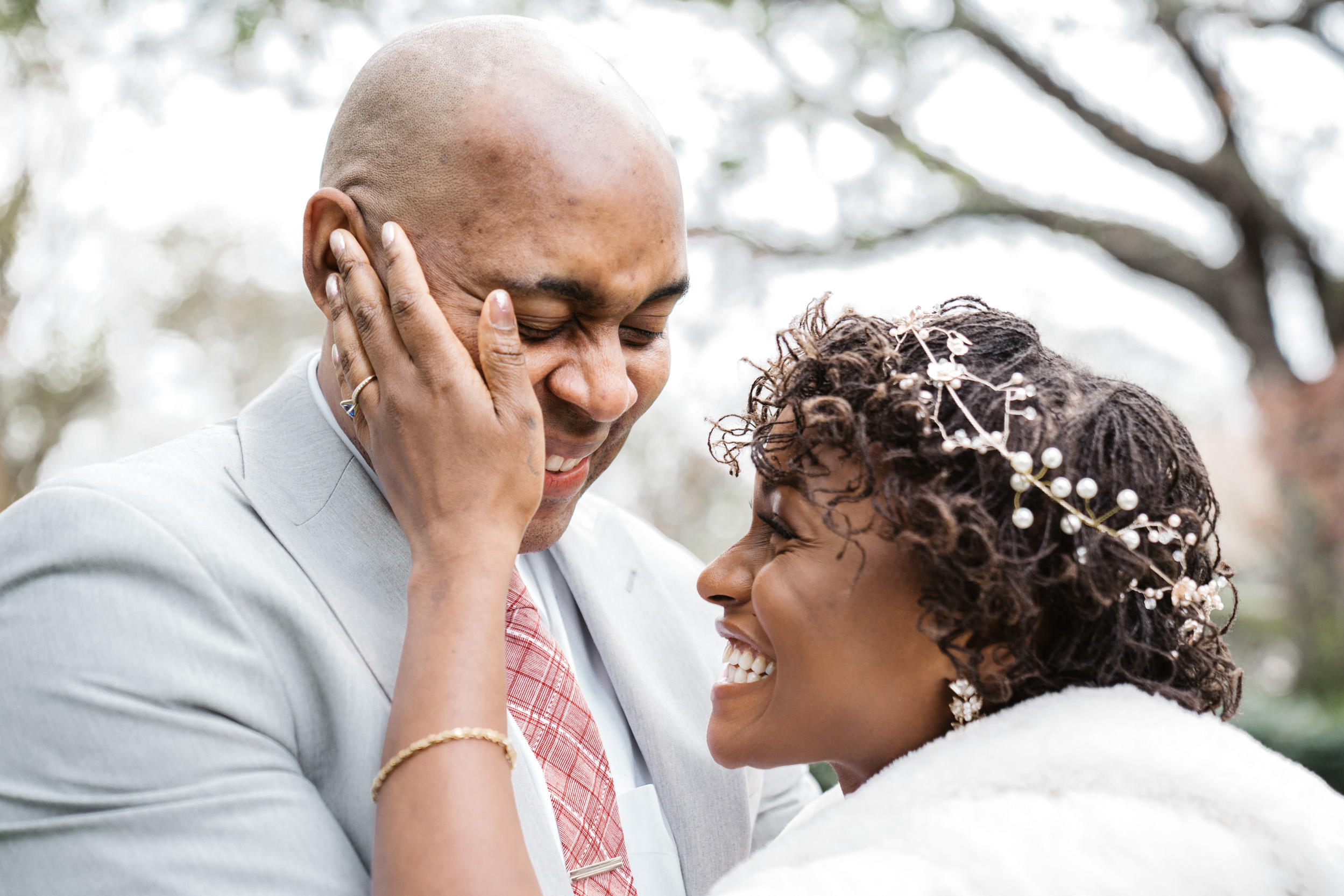 bride and groom laughing and smiling on wedding day at Audubon Park in New Orleans