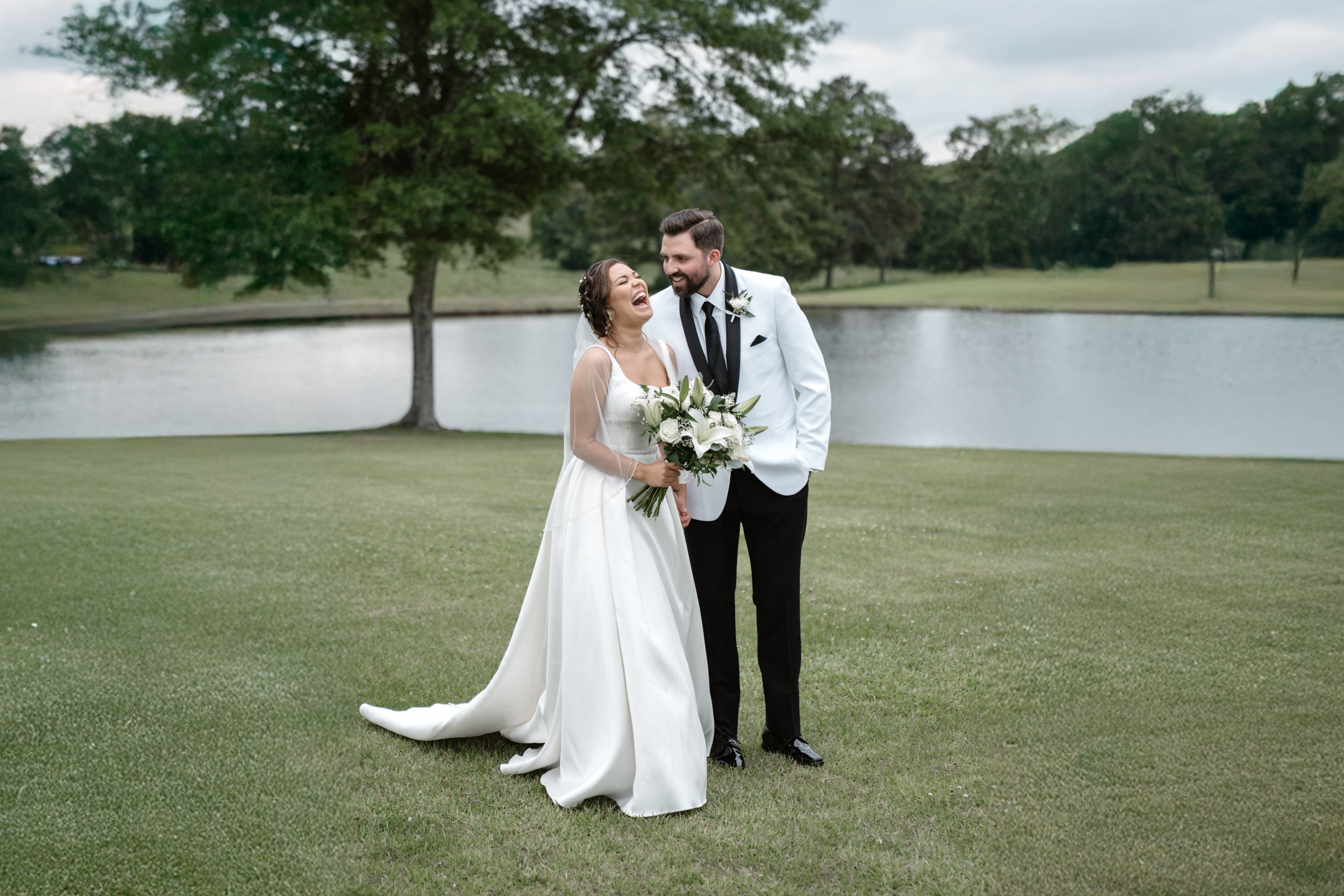 bride and groom laughing in a field at White Magnolia in Kentwood, Louisiana